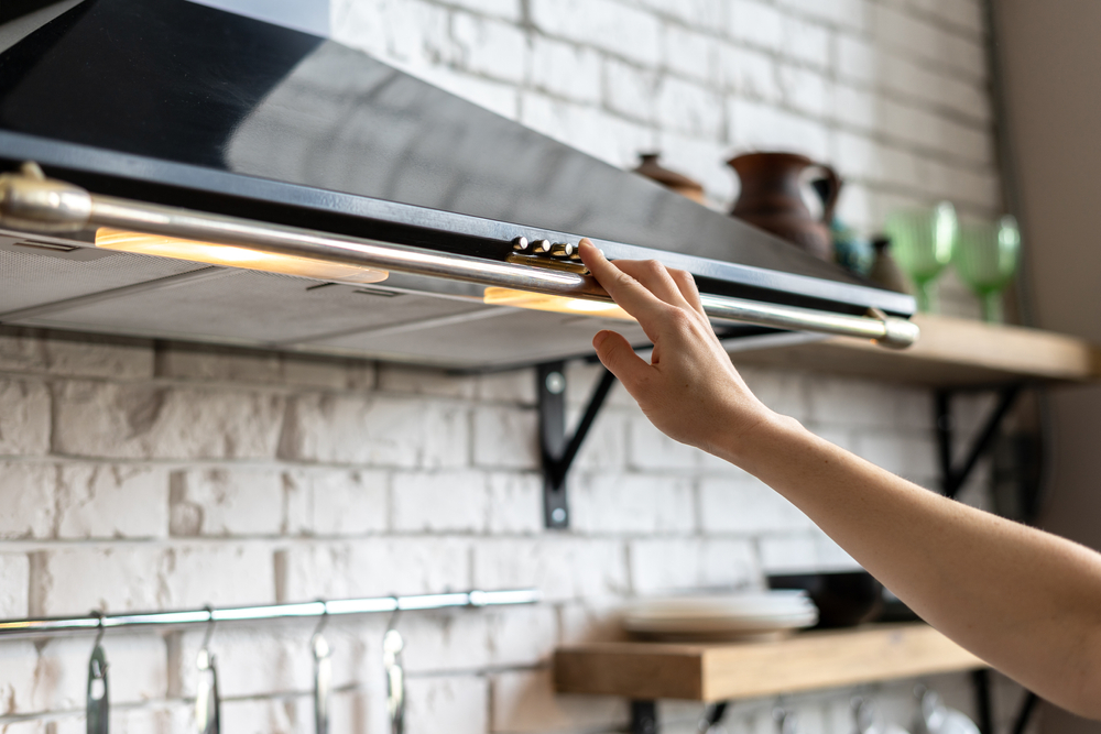 Cropped,view,of,woman,hand,select,mode,on,cooking,hood,