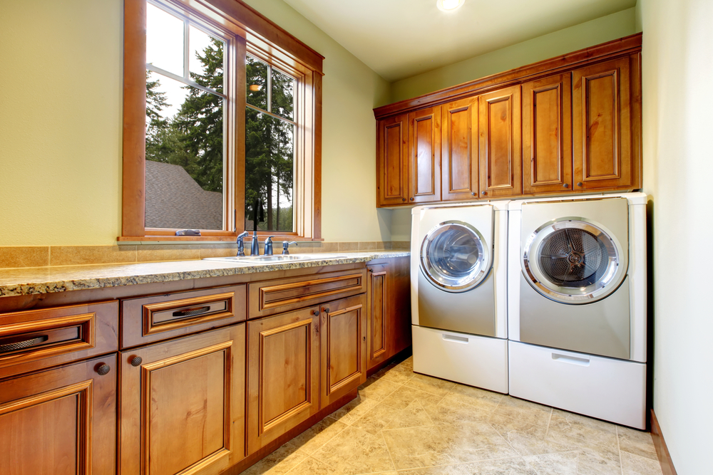 Luxury,laundry,room,with,wood,cabinets,and,tile,floor.